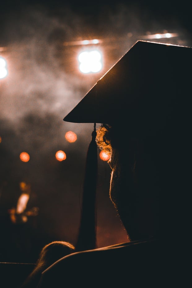 Silhouette of a graduate under stage lights