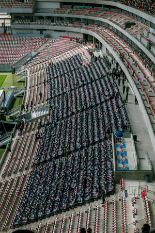 Aerial view of graduates seated in rows in a stadium