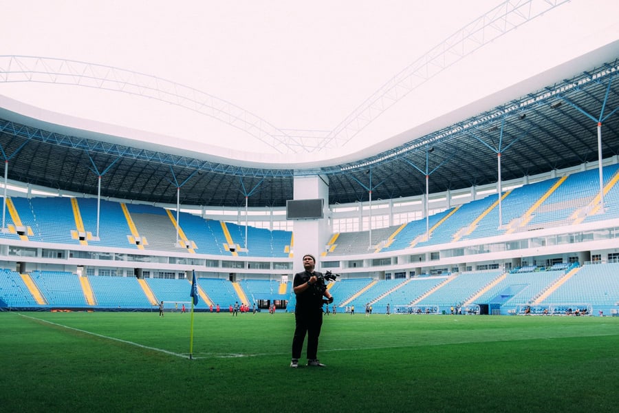 Photographer shooting from the pitch inside a stadium