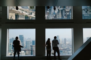 Guests silhouetted at windows over a city skyline