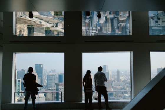 Guests silhouetted at windows over a city skyline