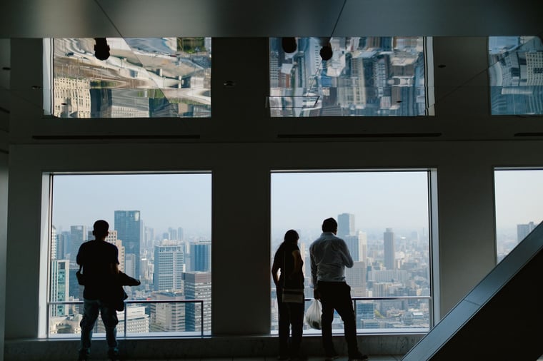 Guests silhouetted at windows over a city skyline