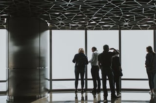 Guests at an observation deck window with the view lost in fog