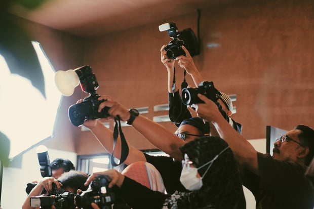 Photographers capturing an indoor event with flash