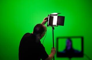 Studio lights set up in front of a green screen