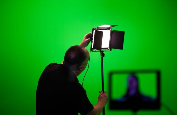 Studio lights set up in front of a green screen