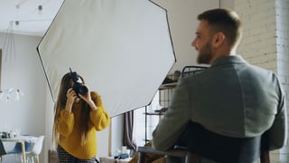 Photographer lighting a studio portrait session