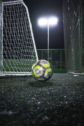 Match ball by the goal under floodlights