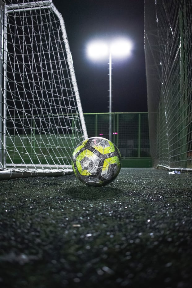 Match ball by the goal under floodlights