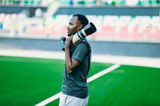 Photographer with a long lens on the sideline