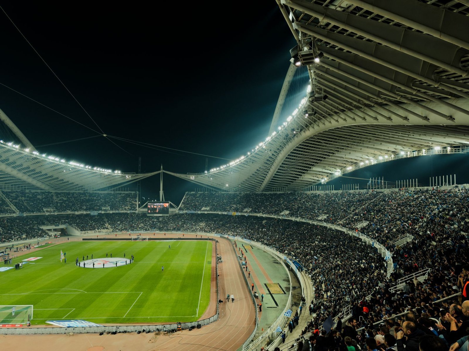 Floodlit stadium full of fans at night