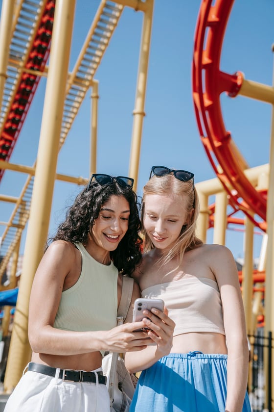 Guests looking at their photos on a phone at a theme park