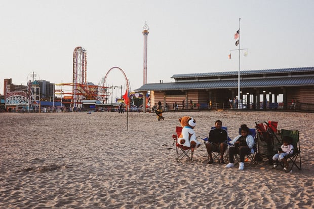 Beach with amusement park rides behind