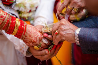 Hands with henna and red bangles during a wedding ritual
