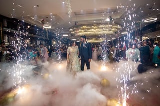 Bride and groom celebrating with guests among sparklers