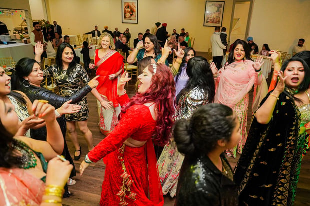 Women dancing together at a sangeet