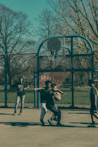 Teenagers playing basketball outdoors