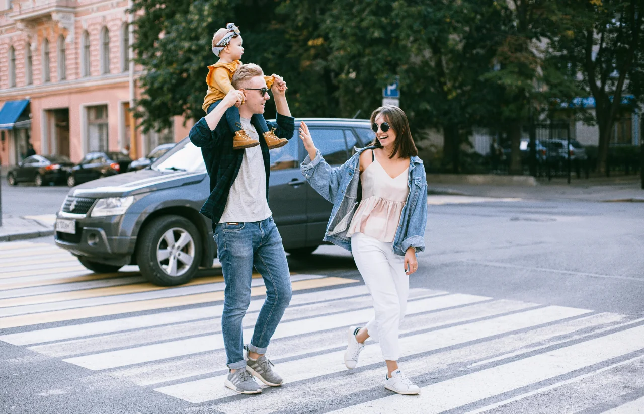 image of a couple crossing road with baby