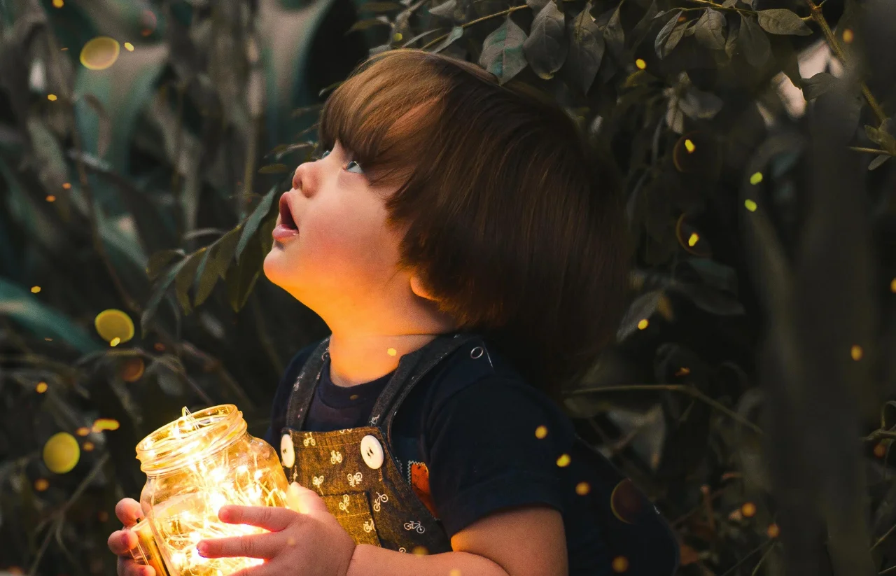 image of a baby playing with fireflies
