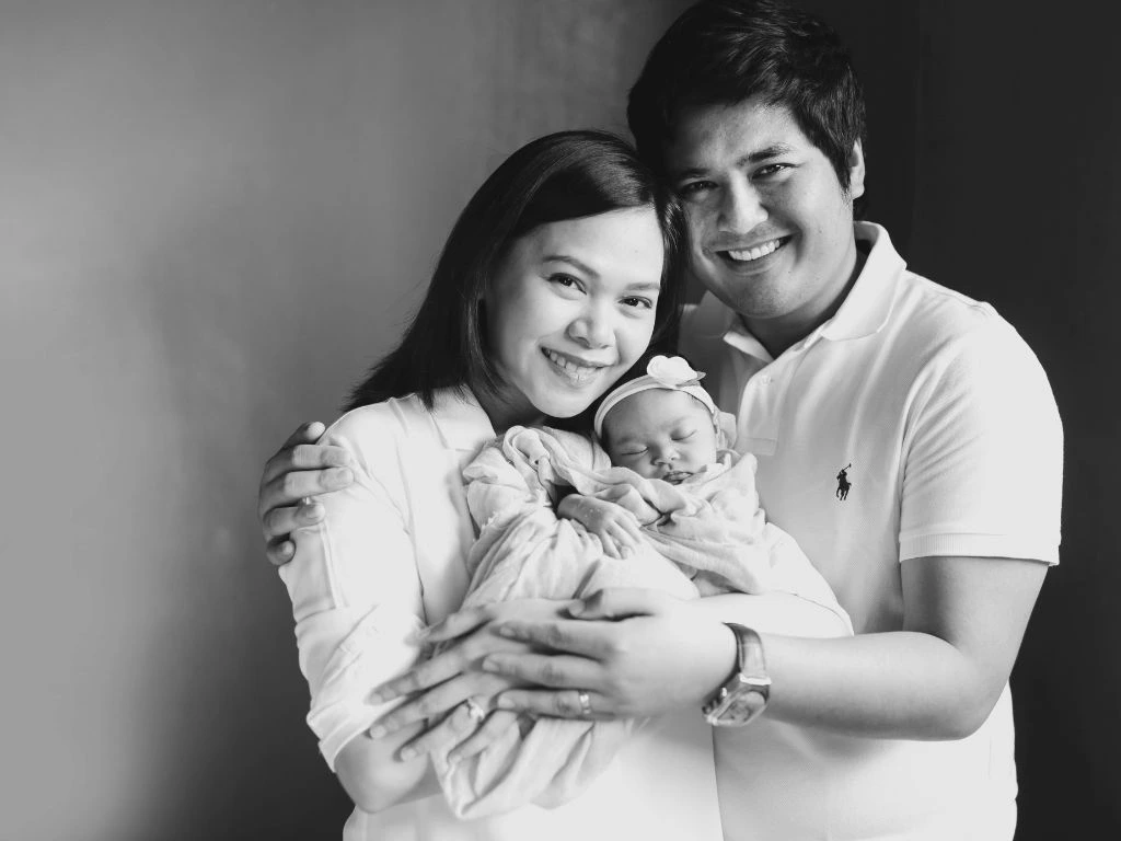 photo of a baby with parents in black and white