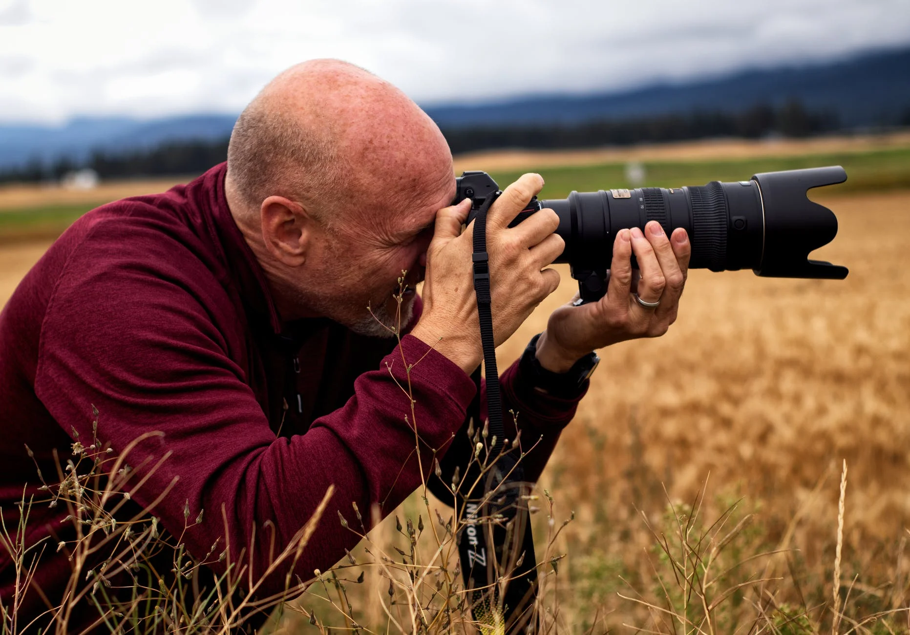 photography of a man holding a DSLR camera while preparing to take a photo