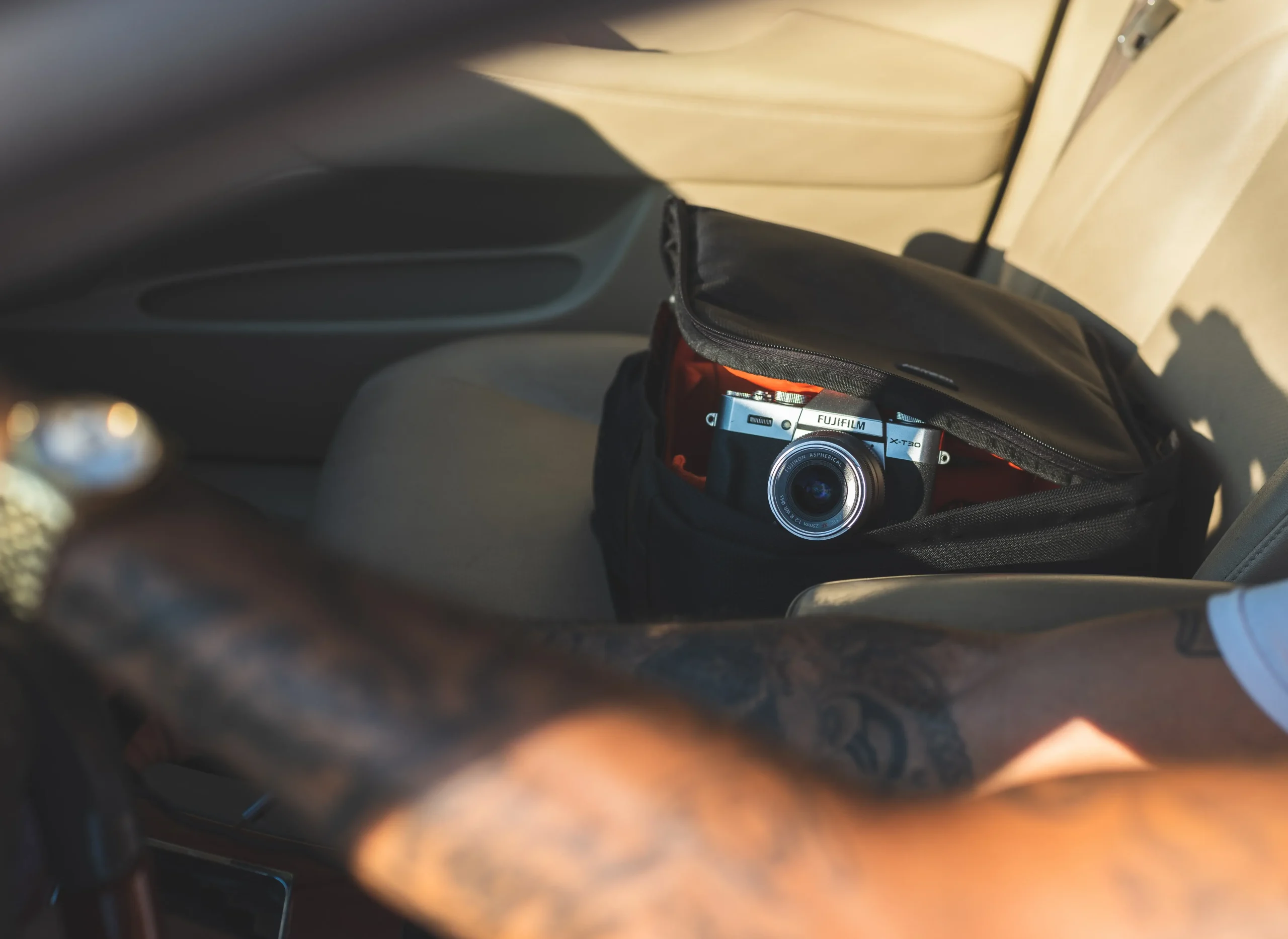 a cropped image of a guy driving beside a camera on a bag